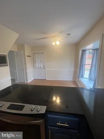 a kitchen with wooden floors and stainless steel appliances