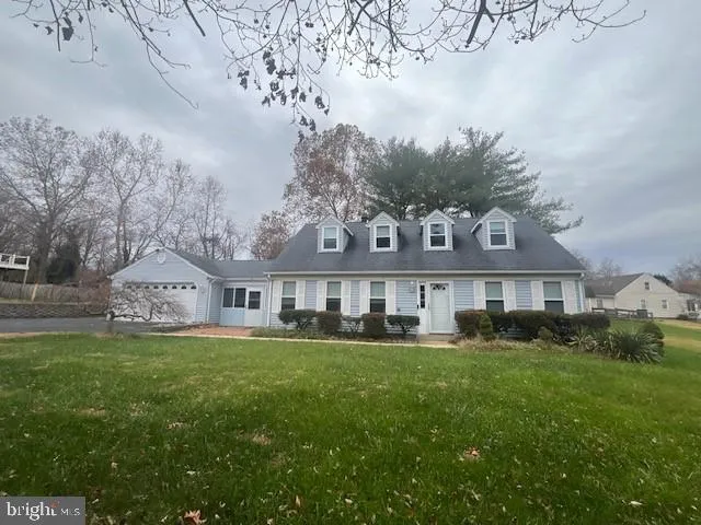 a front view of a house with a garden and trees