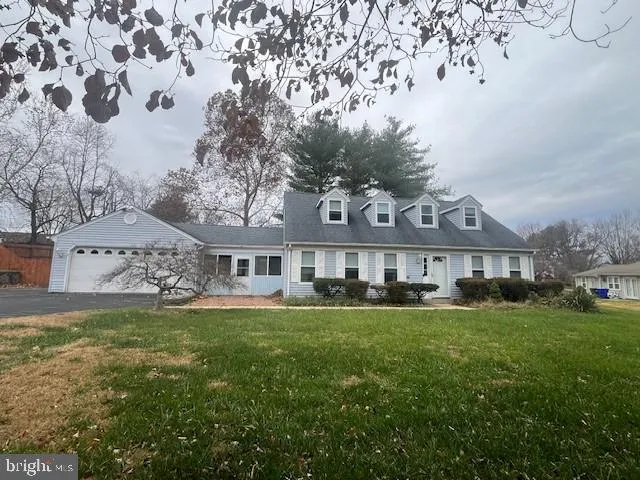 a view of a house with a big yard and large trees