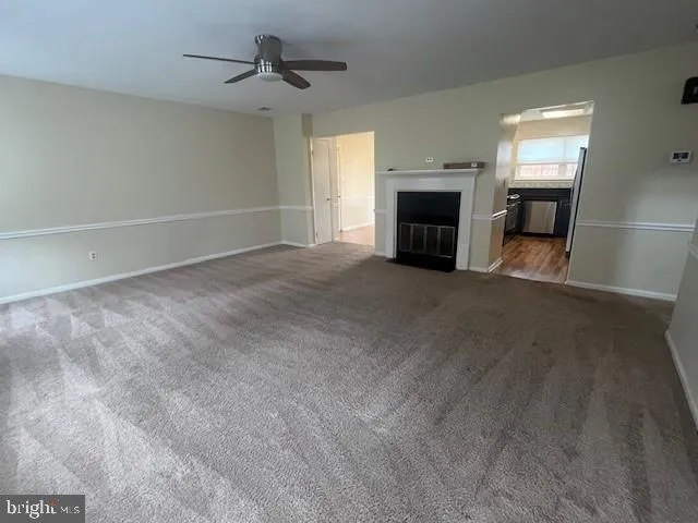 a view of empty room with fireplace and fan