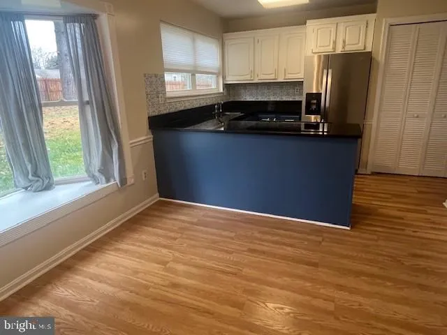 a kitchen with granite countertop a refrigerator a stove a sink and a window