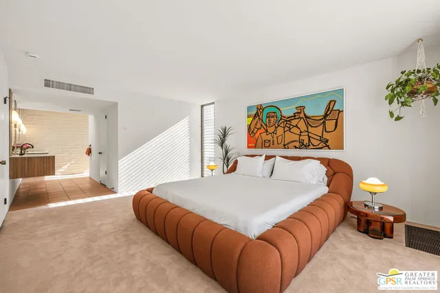 a bedroom with a bed and painting on the wall