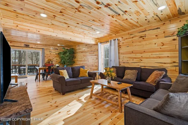 a living room with furniture a flat screen tv and kitchen view
