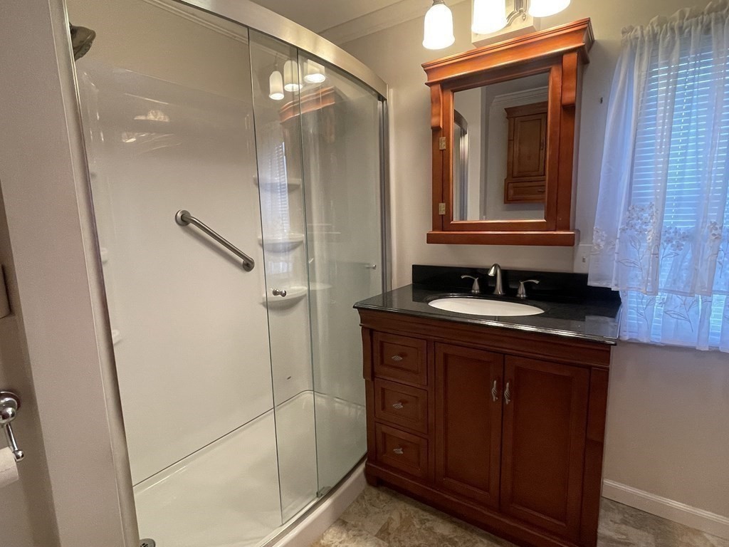 239 Ayer Road, Unit 49 Littleton, MA 01460 - Photo 14 of 21 a bathroom with a double vanity sink a mirror and a shower