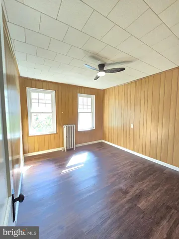 a view of empty room with window and wooden floor