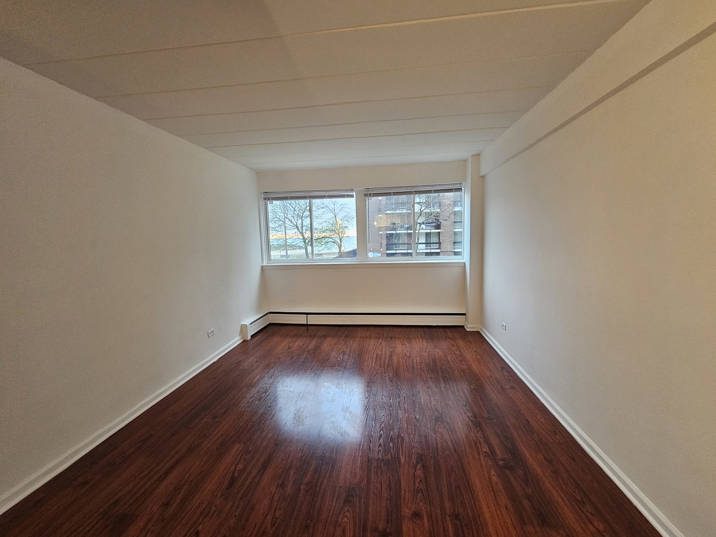 5906 North Sheridan Road, Unit 4A Chicago, IL 60660 - Photo 11 of 15 an empty room with wooden floor and windows