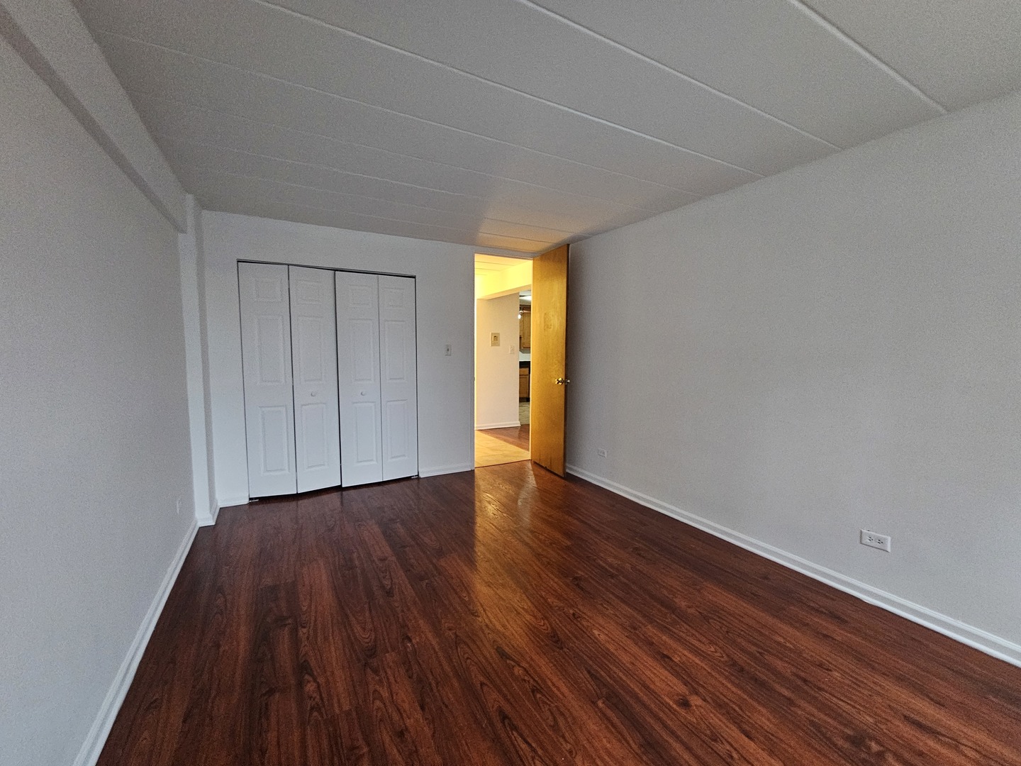 5906 North Sheridan Road, Unit 4A Chicago, IL 60660 - Photo 12 of 15 a view of an empty room with wooden floor and a window