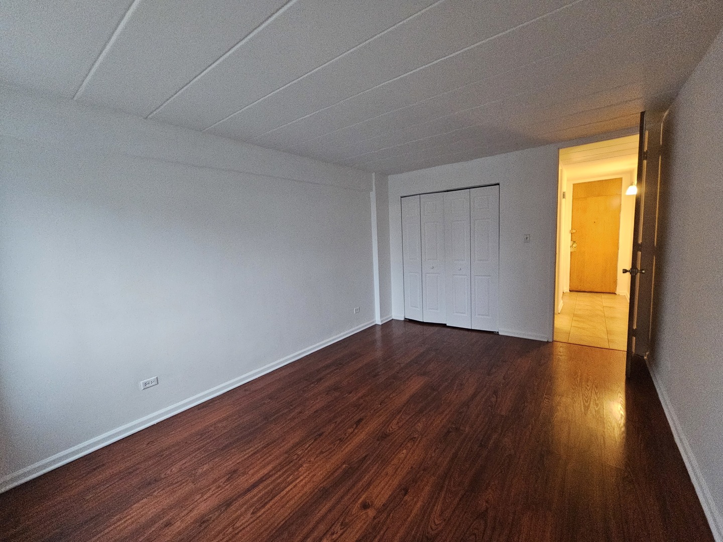 5906 North Sheridan Road, Unit 4A Chicago, IL 60660 - Photo 13 of 15 a view of an empty room with wooden floor and a window