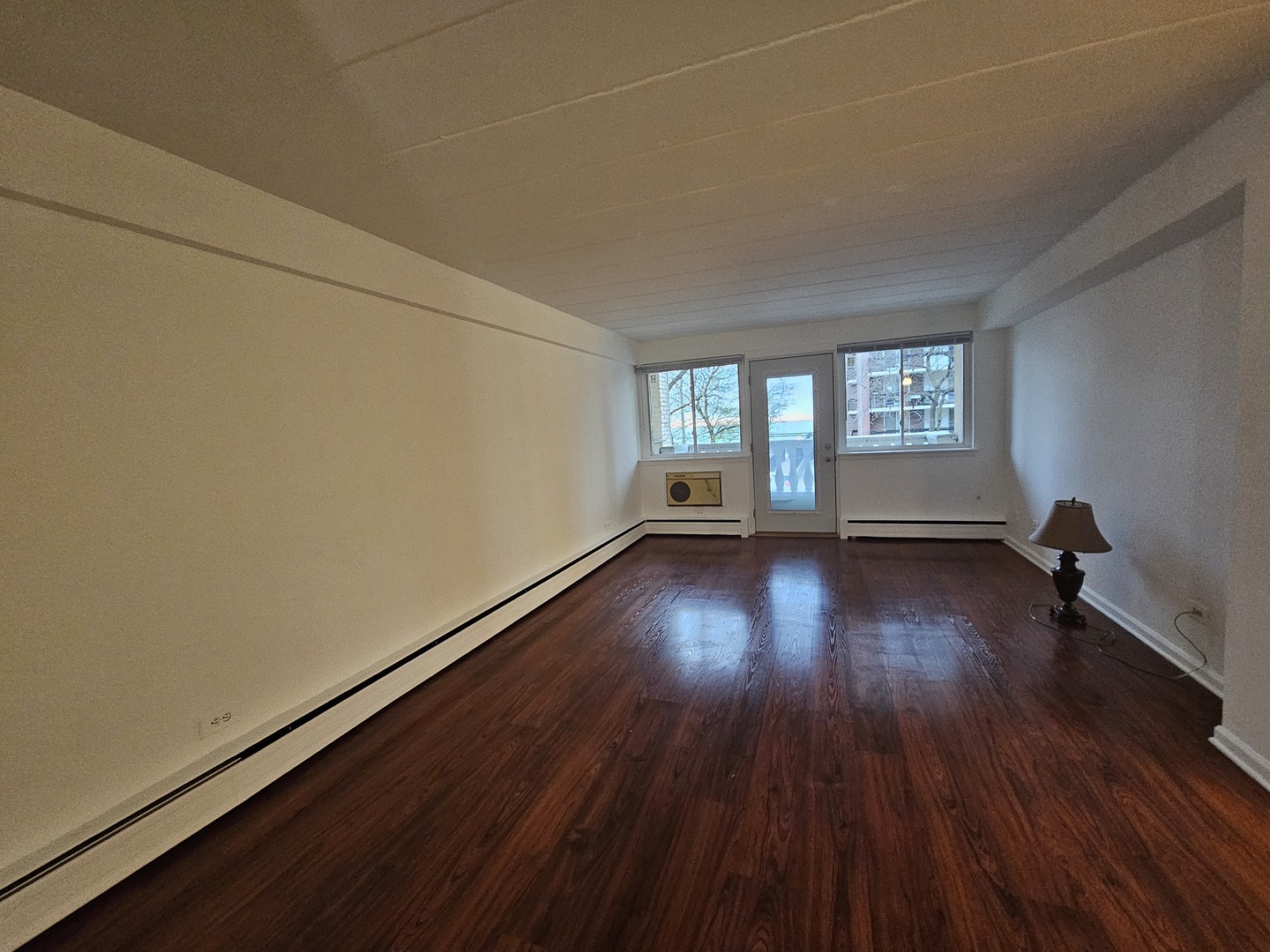 5906 North Sheridan Road, Unit 4A Chicago, IL 60660 - Photo 5 of 15 an empty room with wooden floor and windows