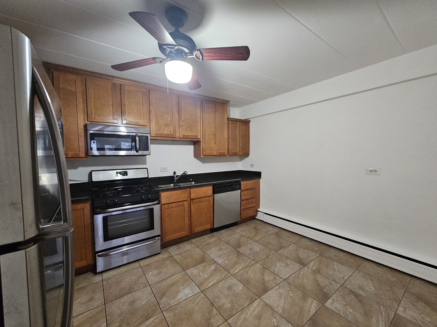 5906 North Sheridan Road, Unit 4A Chicago, IL 60660 - Photo 7 of 15 a kitchen with stainless steel appliances granite countertop a stove a sink and a refrigerator