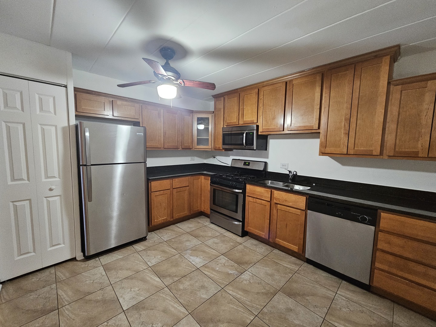 5906 North Sheridan Road, Unit 4A Chicago, IL 60660 - Photo 8 of 15 a kitchen with stainless steel appliances granite countertop a refrigerator sink and cabinets
