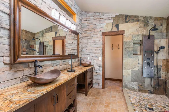 a bathroom with a granite countertop sink and a mirror