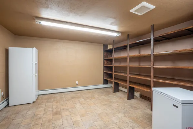 a view of an empty room with a cabinet and a window