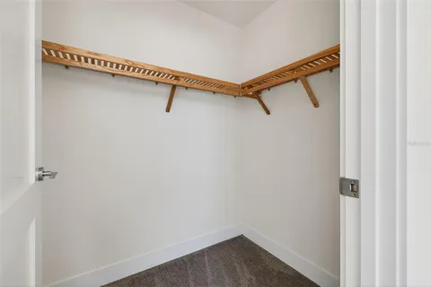 a view of a room with stainless steel appliances wooden floor and table chairs
