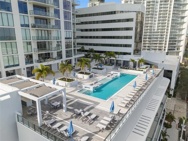 a view of a swimming pool with a patio and a fire pit