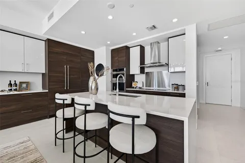 a kitchen with stainless steel appliances kitchen island wooden cabinets and a stove top oven