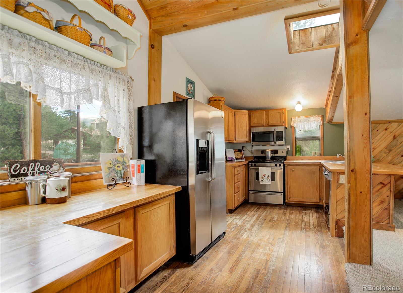 77 East Crosscut Road Bailey, CO 80421 - Photo 20 of 43 a kitchen with refrigerator cabinets and wooden floor