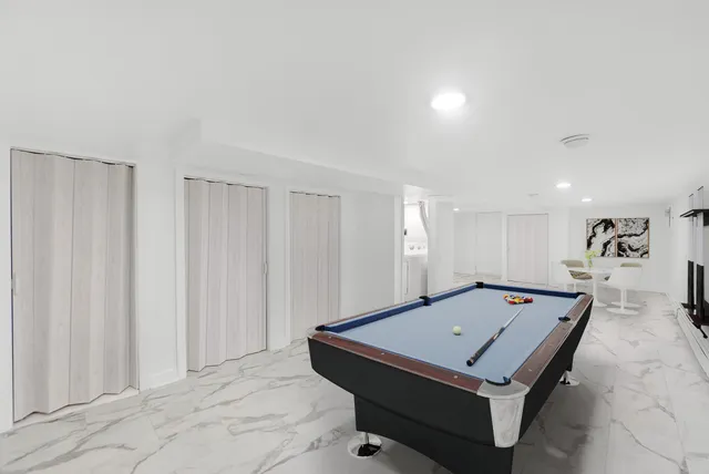 a room with pool table and a window