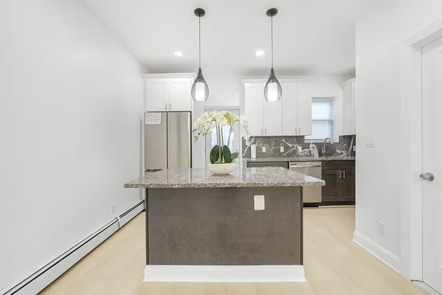 a kitchen with kitchen island a counter top space a sink and appliances