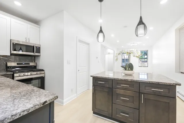 a kitchen with granite countertop cabinets a sink and stainless steel appliances