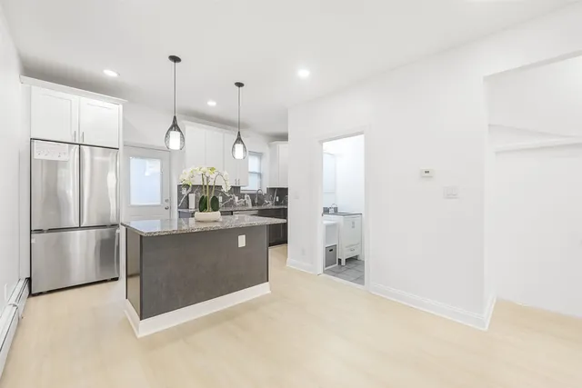 a large kitchen with a refrigerator and a sink
