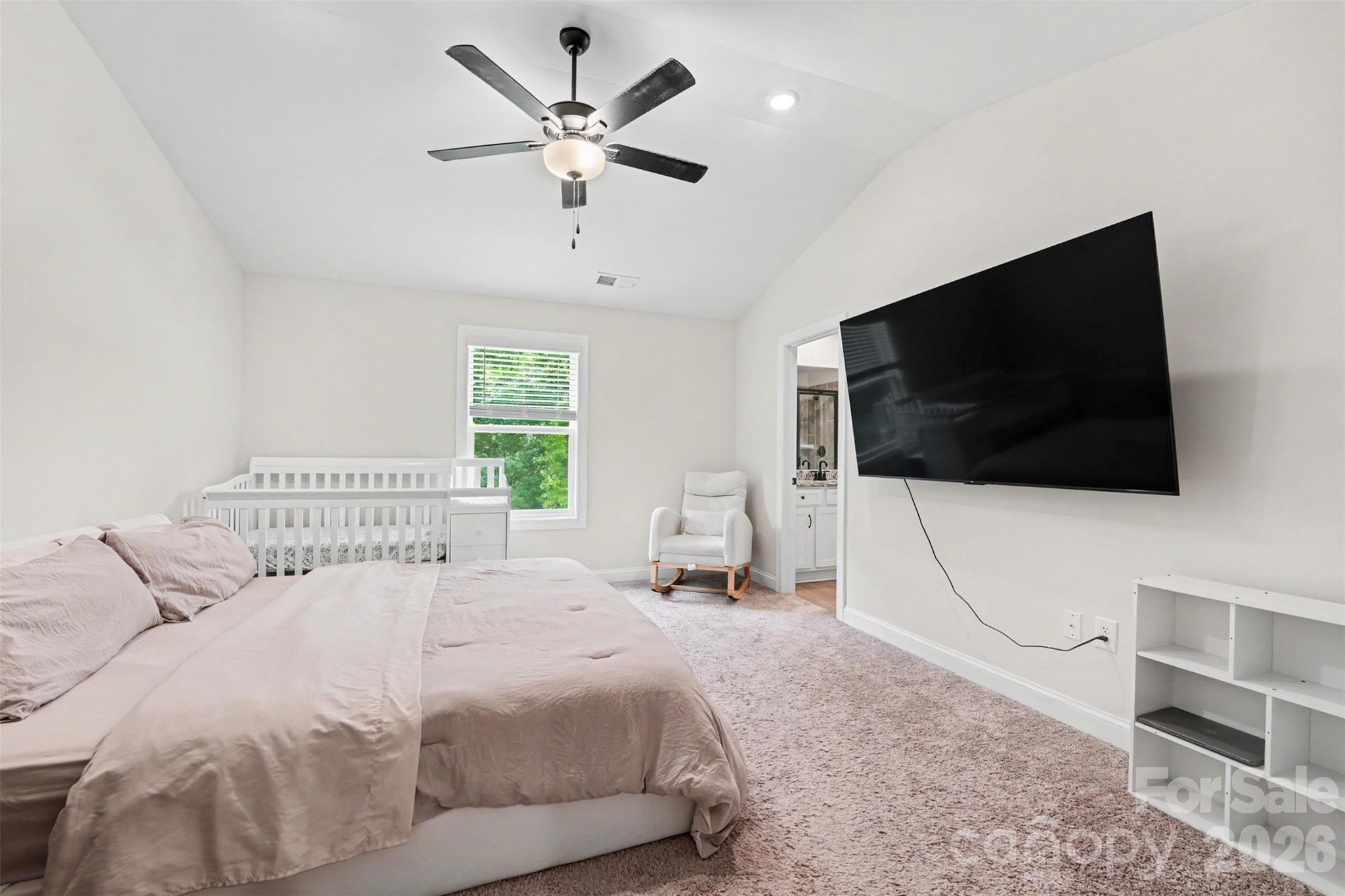 123 Brixham Loop Troutman, NC 28166 - Photo 13 of 18 a bedroom with a bed a flat screen tv and a fireplace