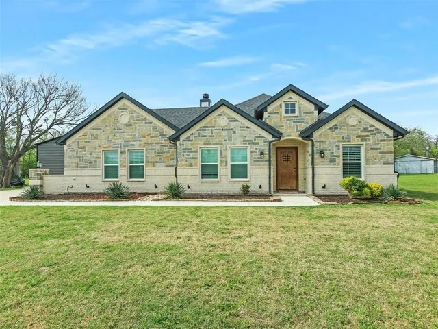 a front of a house with a garden and porch