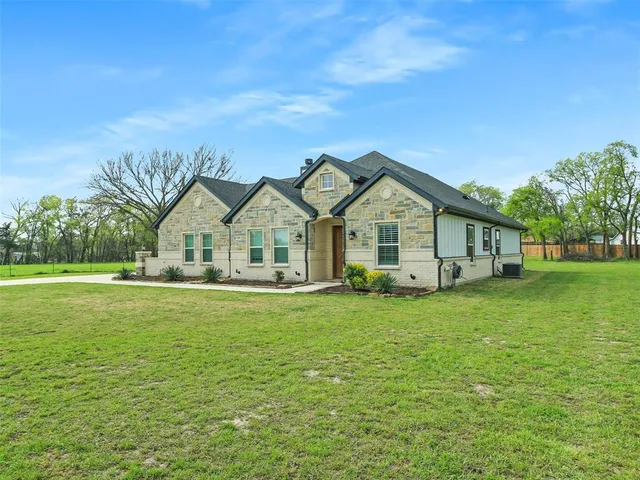 a view of a house with a big yard and large trees