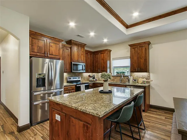 a kitchen with granite countertop stainless steel appliances and wooden cabinets