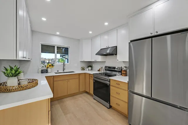 a kitchen with granite countertop a refrigerator stove and sink