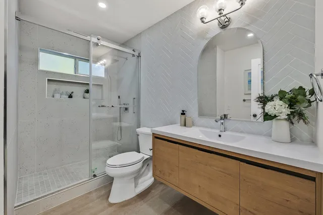 a bathroom with a sink a toilet and shower