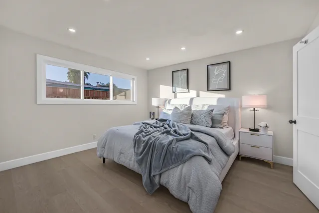 a spacious bedroom with a bed and a painting