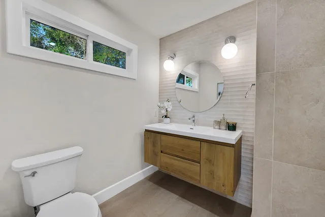 a bathroom with a toilet sink and mirror