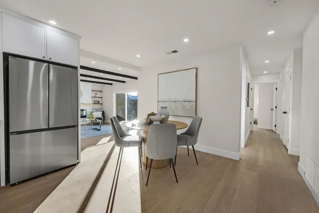 a view of a dining room with furniture and a refrigerator