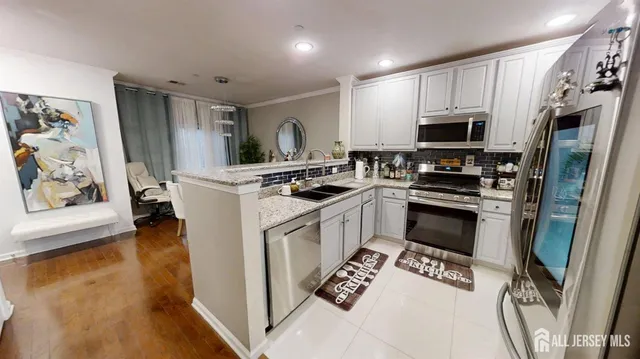 a kitchen with stainless steel appliances a stove a sink refrigerator and a microwave