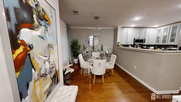 a dining room with stainless steel appliances kitchen island granite countertop furniture a rug and a window