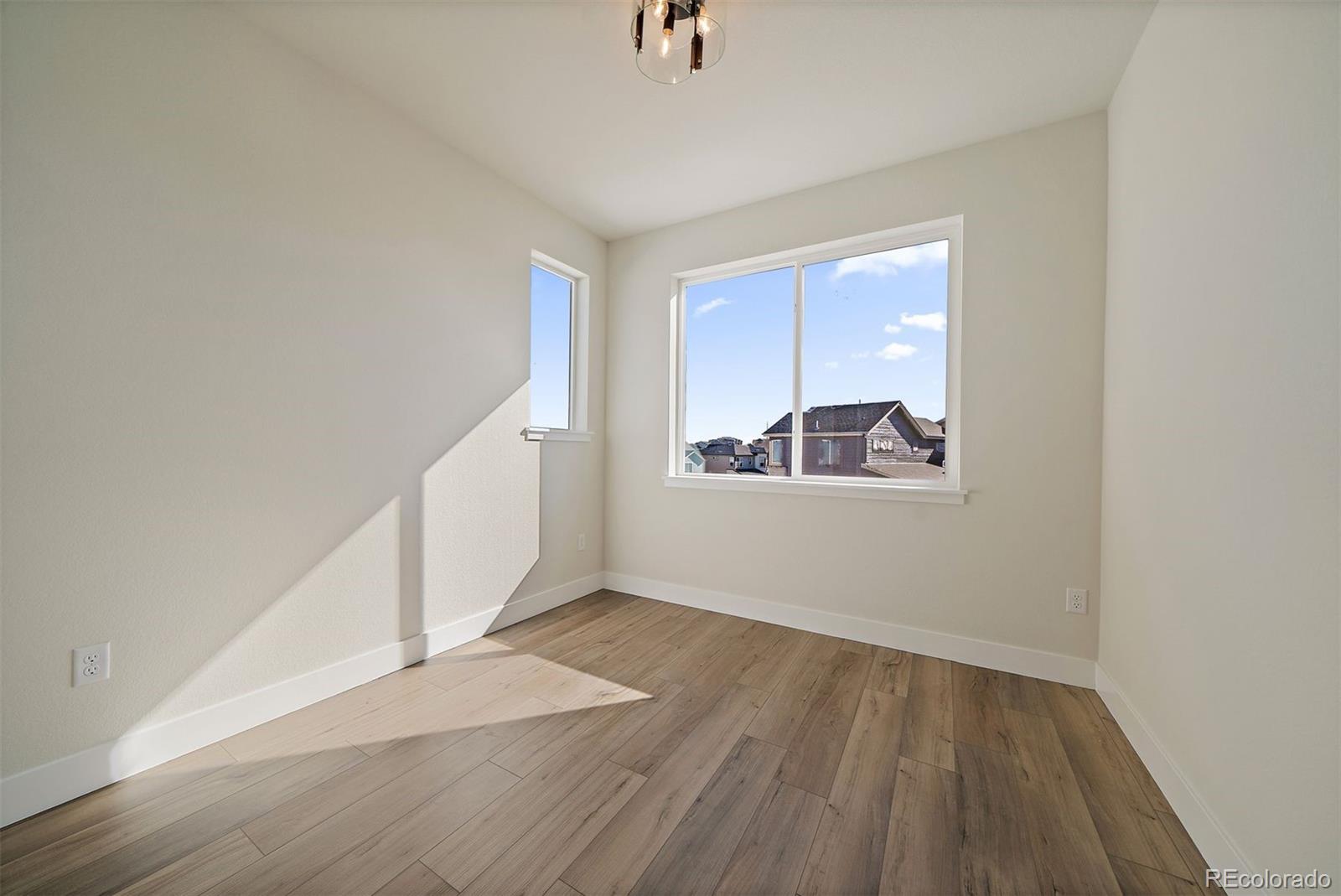 10882 Lyric Street Parker, CO 80134 - Photo 19 of 25 a view of an empty room with wooden floor and a window