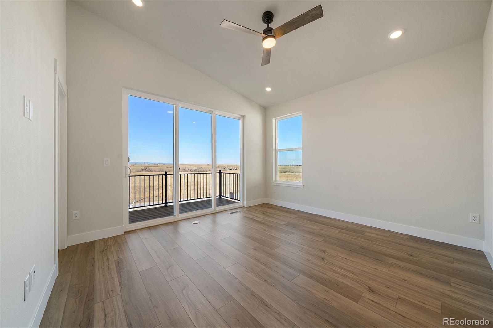 10882 Lyric Street Parker, CO 80134 - Photo 20 of 25 an empty room with wooden floor fan and windows