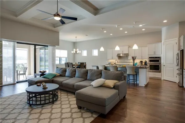 a living room with furniture kitchen and a large window