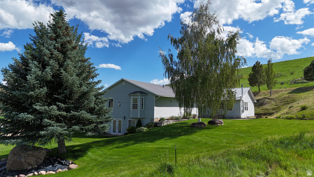9029 North Treasureton Road Preston, ID 83263 - Photo 29 of 31 Expansive green lawn bordering a two-story residence with light blue siding and a bay window