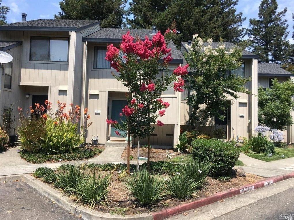 a front view of a house with a yard and fountain