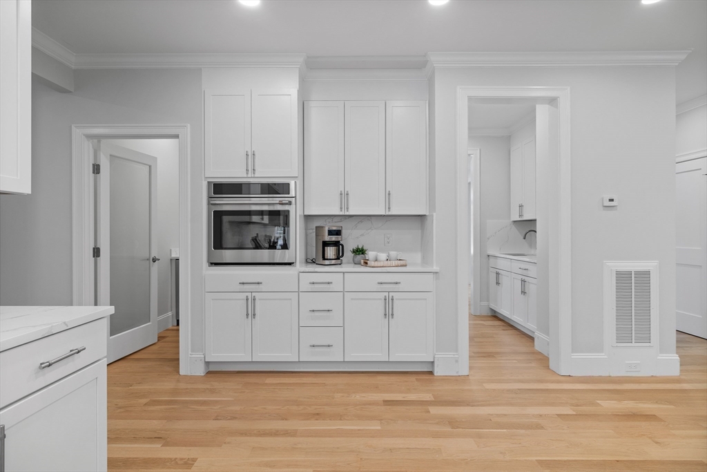 103 Wayne Road Needham, MA 02494 - Photo 10 of 29 a kitchen with stainless steel appliances white cabinets and a refrigerator