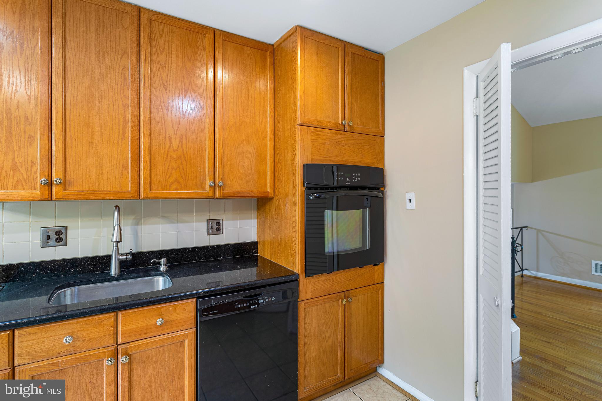 6503 Friars Court Bethesda, MD 20817 - Photo 18 of 48 a kitchen with granite countertop wooden cabinets and stainless steel appliances
