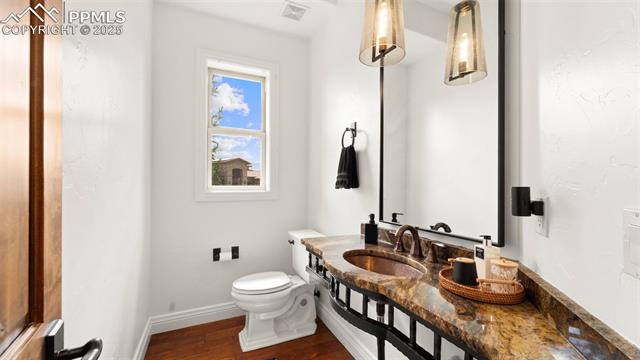 13625 Random Ridge View Colorado Springs, CO 80921 - Photo 16 of 50 Half bath with dark wood-style floors and vanity
