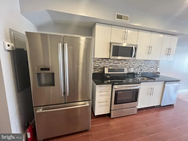 a kitchen with stainless steel appliances granite countertop a refrigerator stove and microwave