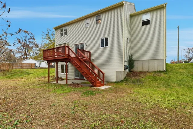 a view of an house with backyard and a tree