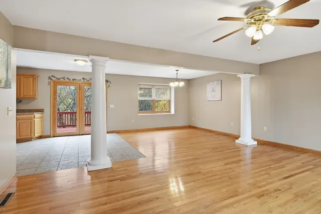 a view of an empty room with window and wooden floor