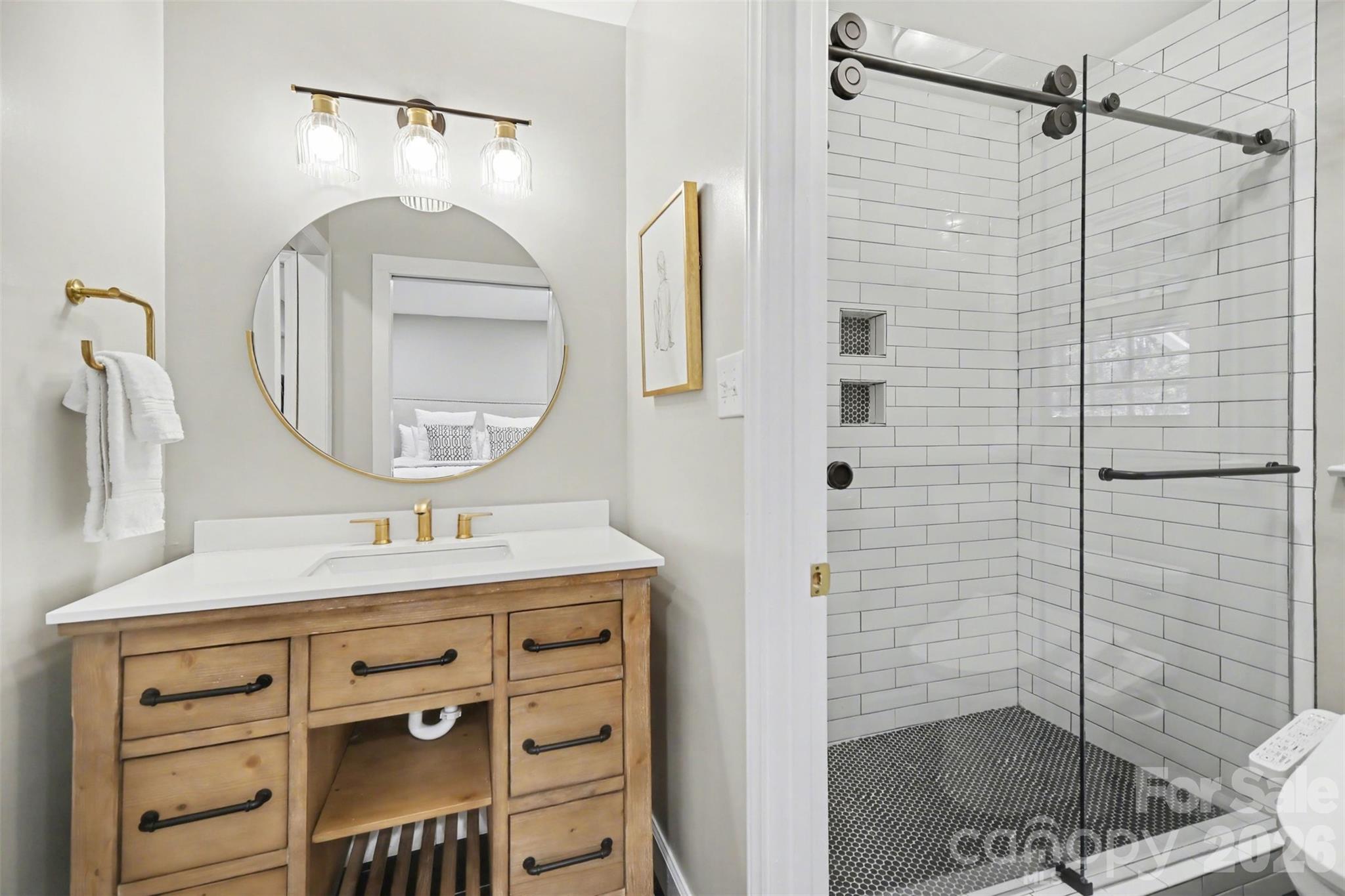 6008 Alexa Road Charlotte, NC 28277 - Photo 39 of 46 a bathroom with a sink a vanity a mirror and shower