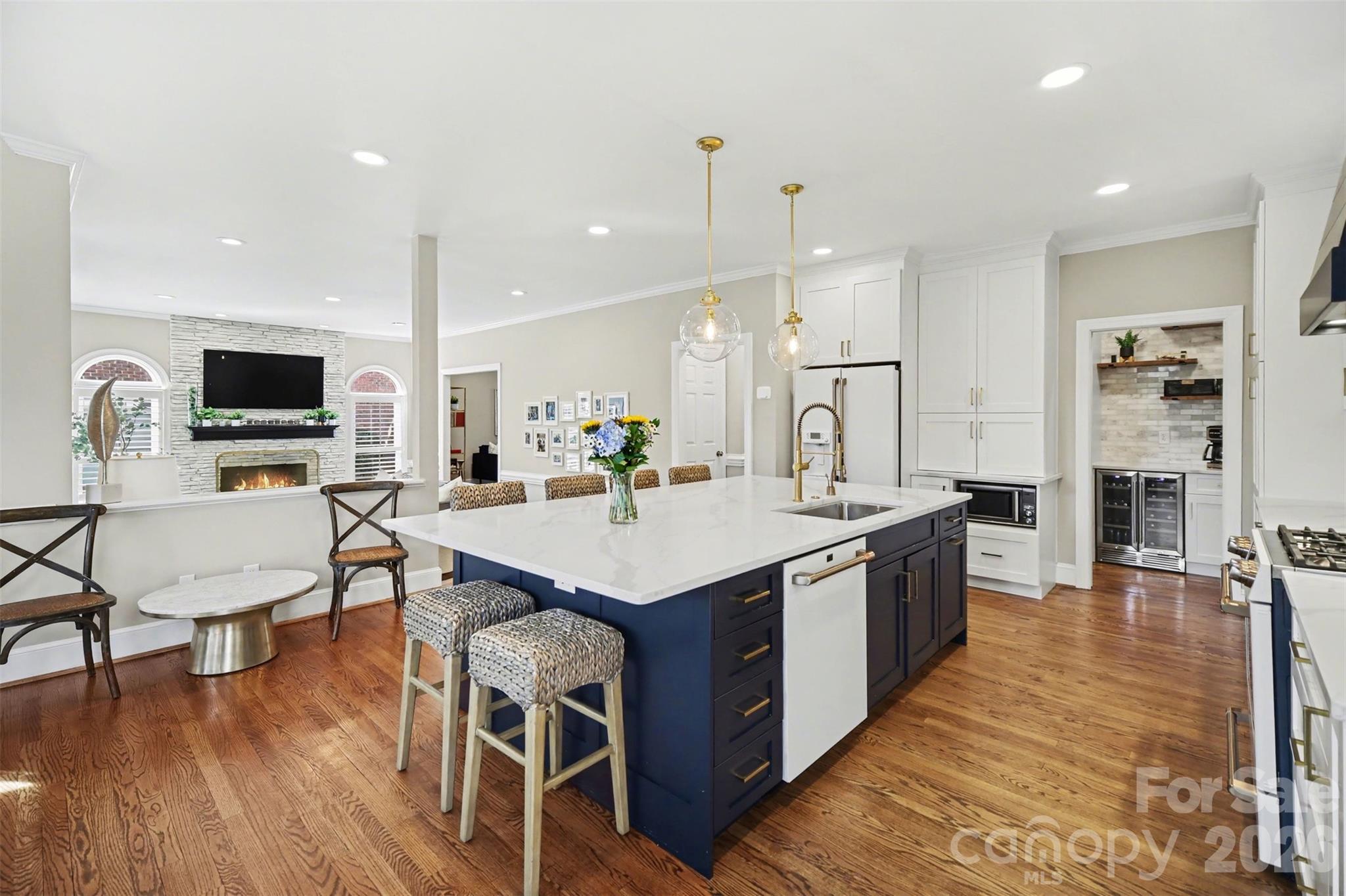 6008 Alexa Road Charlotte, NC 28277 - Photo 9 of 46 a open kitchen with stainless steel appliances granite countertop a stove top oven a sink dishwasher a dining table and chairs with wooden floor
