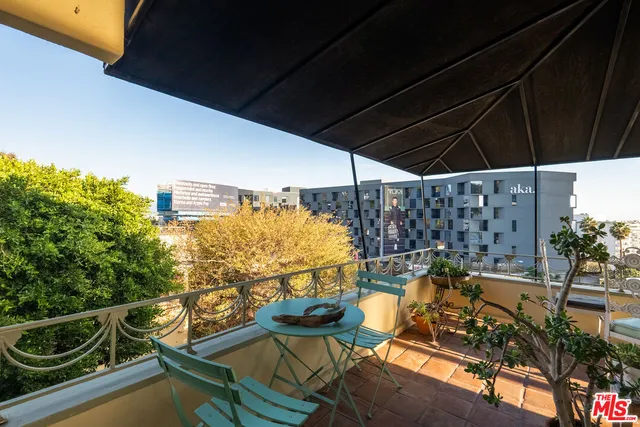 a view of a balcony with chairs and wooden floor